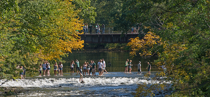 Photo of students standing in the Red Cedar River