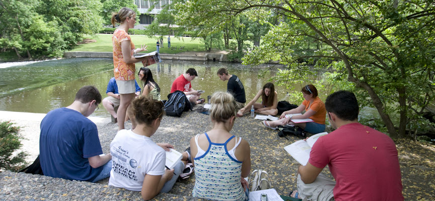 Photo of students studying by the Red Cedar River