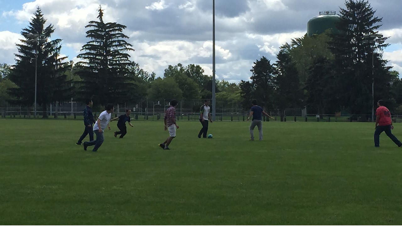 MSIM students playing soccer in a field.